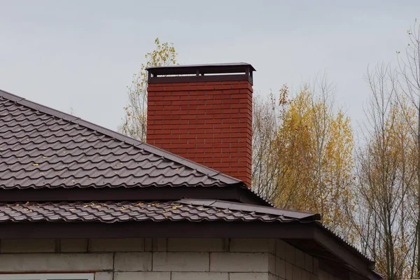 茶色のタイル張りの屋根の上に大きなレンガの煙突が — ストック写真