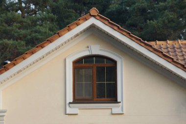 one large brown window on the gray wall of the attic house