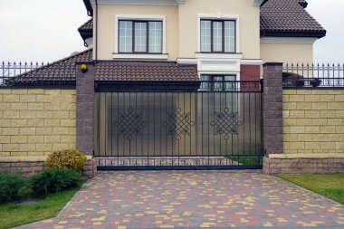  Demirden bir kapı ve kırsal bir sokakta çitin bir kısmı.