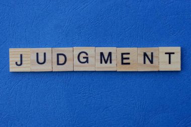 Gri ahşap harflerden yapılmış kelime yargısı mavi bir arka planda yatar