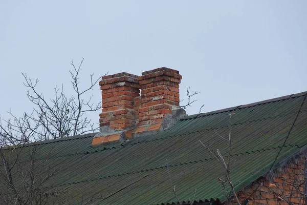 Duas Chaminés Velhas Marrons Telhado Verde Ardósia Contra Céu Cinza — Fotografia de Stock