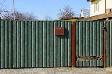 Sokakta özel metal bir çitin kapalı yeşil kapısı.