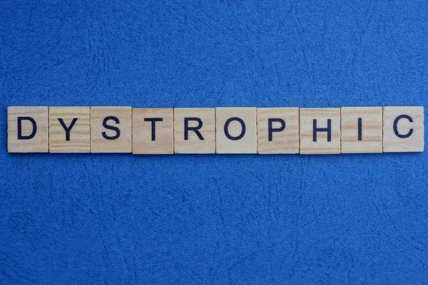 Word Dystrophic Made Wooden Letters Lies Blue Table — Stock Photo, Image