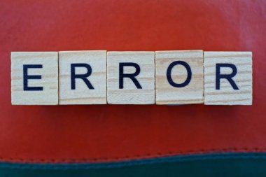 Tahta harflerden yapılan kelime hatası kırmızı arkaplanda yatar