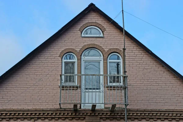 Mavi Gökyüzüne Karşı Demir Balkonu Olan Kahverengi Tuğlalı Çatı Katı — Stok fotoğraf