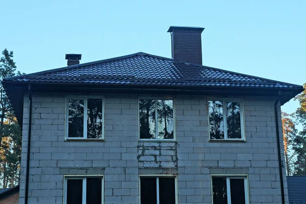 Graues Backsteinhaus Mit Weißen Fenstern Unter Einem Braunen Ziegeldach Gegen — Stockfoto