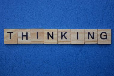 Mavi masadaki küçük ahşap harflerden gelen gri kelime.