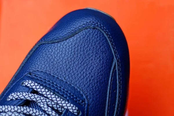Deel Van Een Blauwe Lederen Sneaker Een Rode Achtergrond — Stockfoto