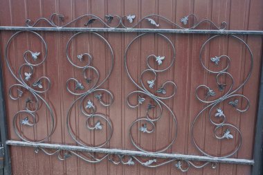 Demir bir duvar çitinde dövülmüş desenli siyah parmaklıkların metal dokusu