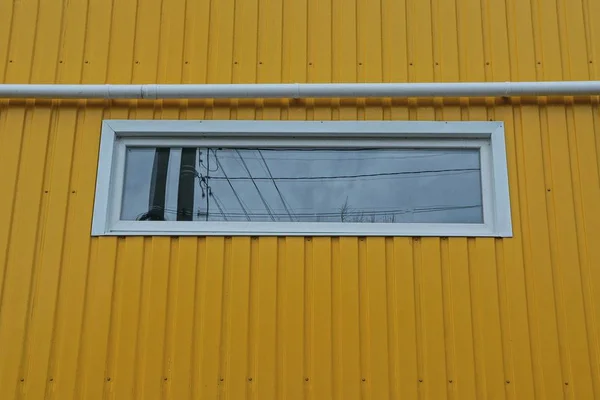 Uma Janela Branca Tubo Ferro Parede Plástico Amarelo Uma Casa — Fotografia de Stock