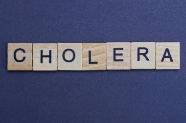 Siyah bir masanın üzerindeki küçük tahta harflerden gelen kolera.