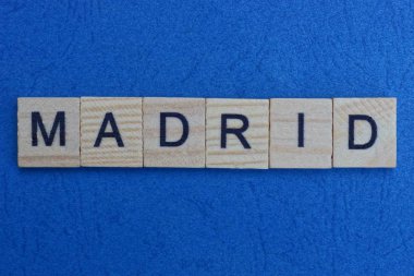 Mavi masadaki küçük tahta harflerden gelen gri kelime Madrid.