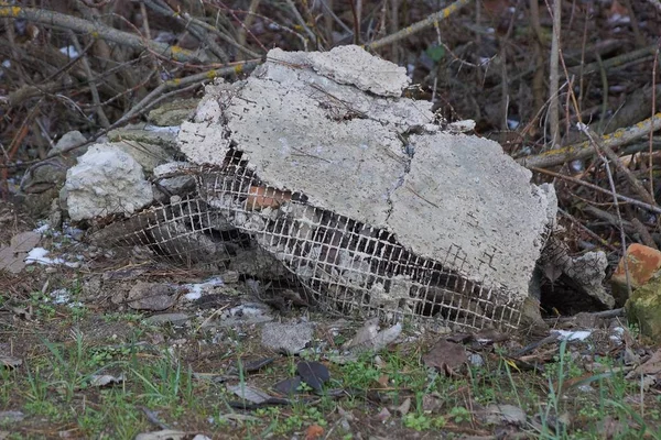 Sterta Gruzu Budowlanego Kawałków Szarego Betonu Zielonej Trawie Suchych Gałęziach — Zdjęcie stockowe