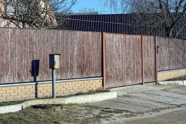 Длинный Коричневый Забор Деревянных Досок Кирпича Закрытыми Воротами Сельской Улице — стоковое фото