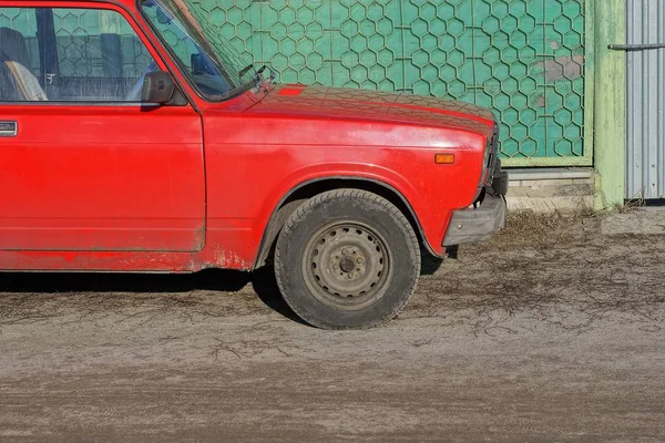 Część Starego Czerwonego Samochodu Osobowego Czarnym Kołem Ziemi Pobliżu Zielonej — Zdjęcie stockowe