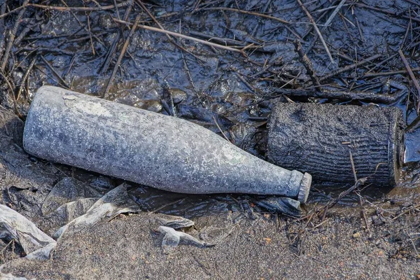1本の灰色の汚れたガラス瓶から出るゴミは地面にあり — ストック写真