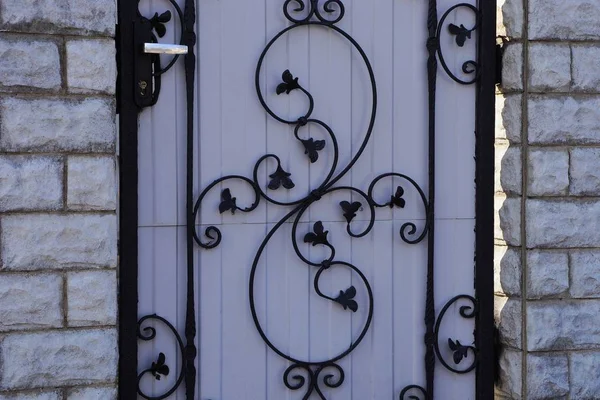 Черный Кованый Железный Узор Серой Металлической Двери Напротив Кирпичной Стены — стоковое фото