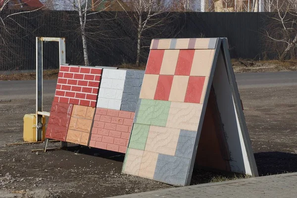 two advertising stands with colored bricks and paving tiles on the street by the road