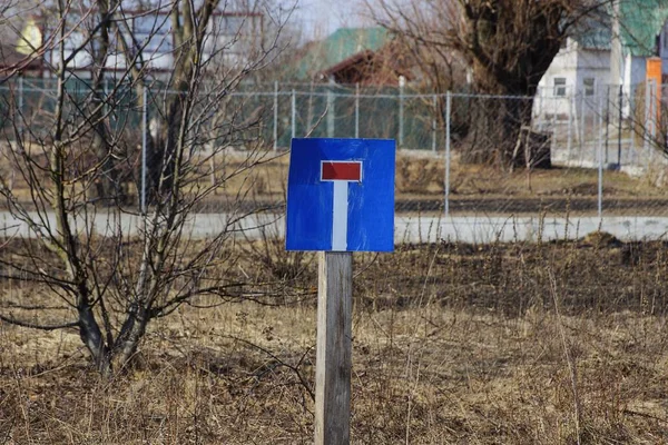正方形的路标竖立在街上干草丛中灰色的木柱上 — 图库照片