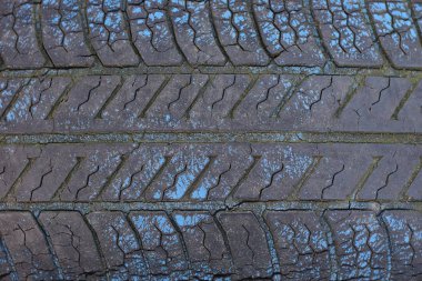 Küçük çatlakları olan eski, kirli bir araba lastiğinin siyah mavi plastik dokusu.