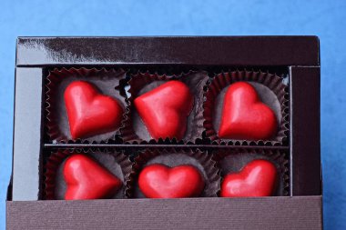 Kahverengi bir karton kutuda duran kırmızı kalp şekeri seti