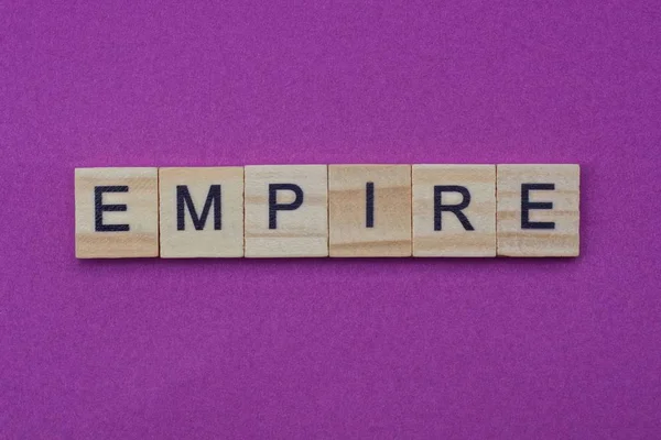 Λέξη Αυτοκρατορία Από Μικρά Γκρι Ξύλινα Γράμματα Βρίσκεται Λιλά Φόντο — Φωτογραφία Αρχείου