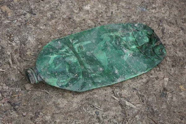 Odpadky Jedné Špinavé Zelené Plastové Láhve Leží Šedém Písku Ulici — Stock fotografie