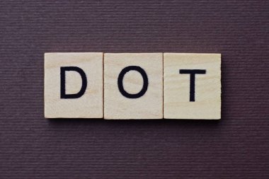  Kahverengi bir masanın üzerindeki küçük tahta harflerden gri bir nokta.