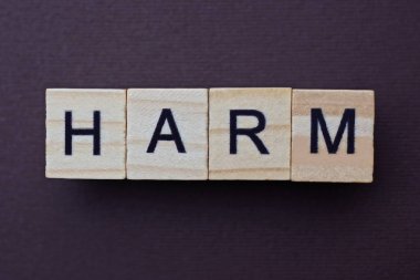 Kahverengi bir masanın üzerindeki küçük tahta harflerden kaynaklanan gri kelime zarar görmüş.