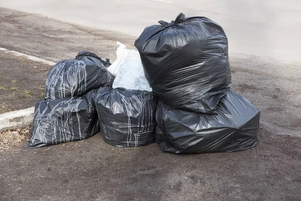 Black Garbage Full Plastic Bags Heap Gray Asphalt Road — Stock Photo, Image