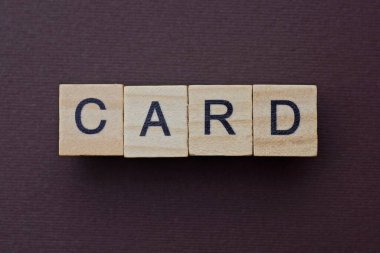 Kahverengi bir masanın üzerindeki küçük tahta harflerden alınan gri kelime kartı.