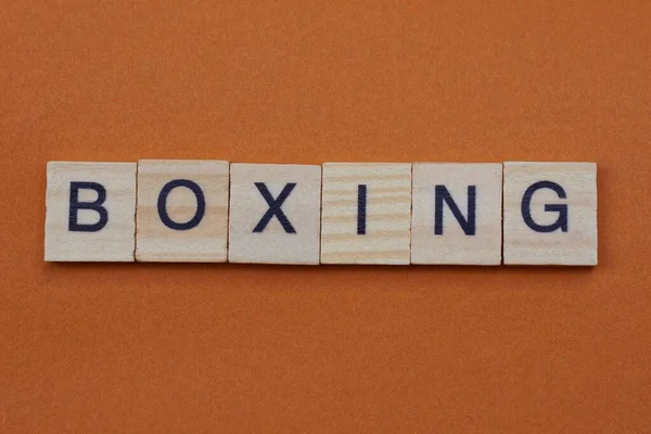 gray word boxing from small wooden letters on a brown table