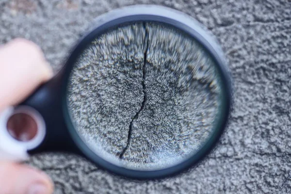 Magnifier Hand Enlarges Black Crack Gray Concrete Wall — Stock Photo, Image