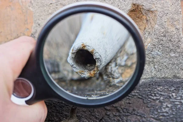 Lente Ingrandimento Nera Mano Allarga Tubo Ferro Bianco Nella Parete — Foto Stock