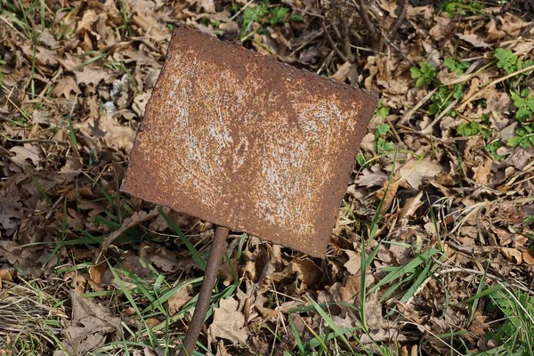 一个褐色铁锈石碑矗立在草地上 干枯的树叶在街上 — 图库照片
