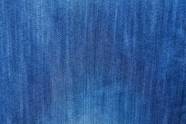 Kot pantolon giymiş eski püskü bir pamuktan mavi kumaş.