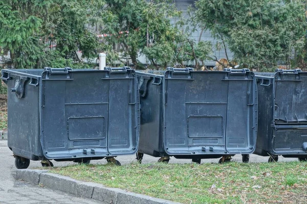 Siyah Plastik Çöp Tenekesi Dışarıda Yeşil Çimlerin Üzerinde Duruyor — Stok fotoğraf