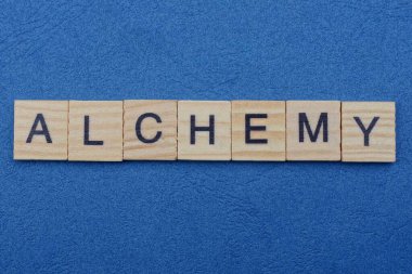 Simya kelimesi küçük gri ahşap harflerden gelir mavi bir arka planda yatar.