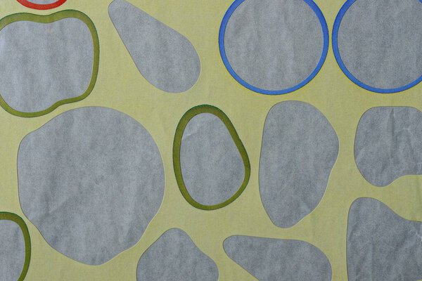 paper texture from a yellow sheet  and a row of gray cut out spots from stickers