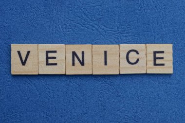 Mavi masadaki küçük ahşap harflerden gri kelime Venedik.