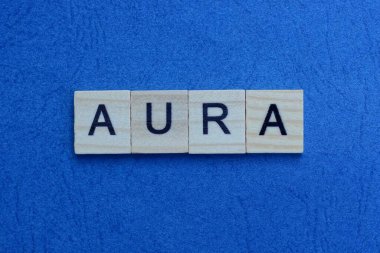 Gri harflerden oluşan aura kelimesi mavi arkaplanda yatar.