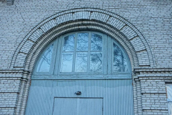 Część Starych Szarych Drewnianych Drzwi Oknem Pod Łukiem Białej Ceglanej — Zdjęcie stockowe