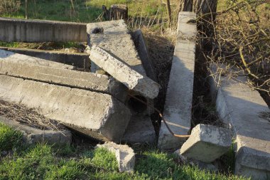 Eski ahşap beton döşemeler sokaktaki yeşil çimlerin üzerinde yatıyor.