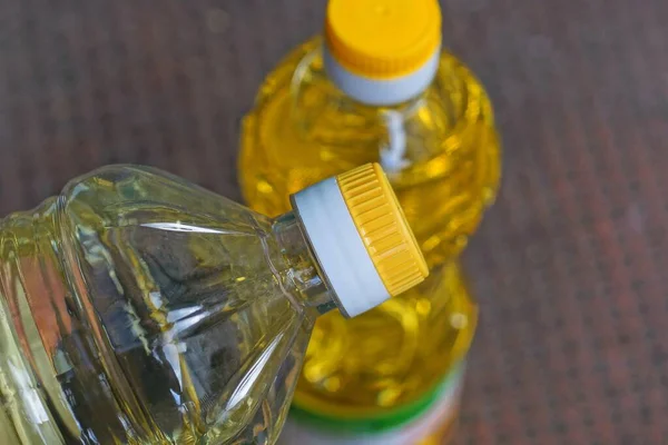 Två Slutna Hela Plastflaskor Med Gul Solrosolja Ett Brunt Bord — Stockfoto