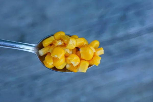 Una Cuchara Metal Llena Maíz Enlatado Amarillo Sobre Fondo Gris — Foto de Stock