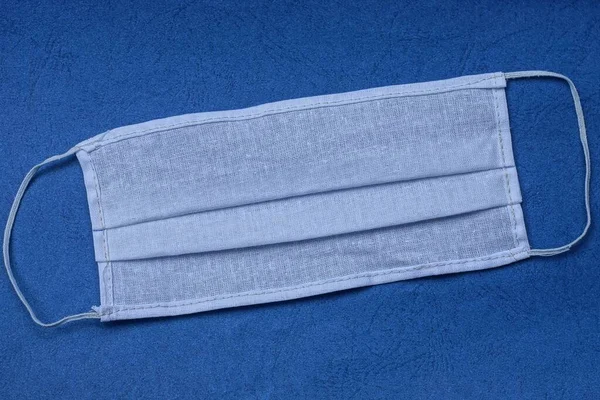 Eine Weiße Medizinische Gaze Maske Liegt Auf Einem Blauen Tisch — Stockfoto