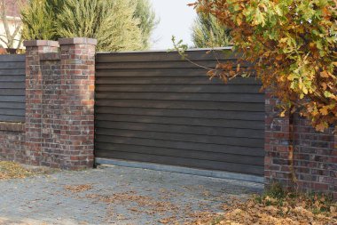 bir kapalı kahverengi kapı ve ahşap tahtalardan çitin bir kısmı 