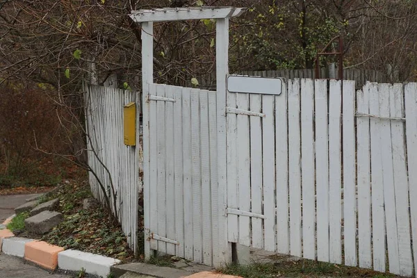 木製の板と通りの閉じたドアから田舎の白いフェンス — ストック写真
