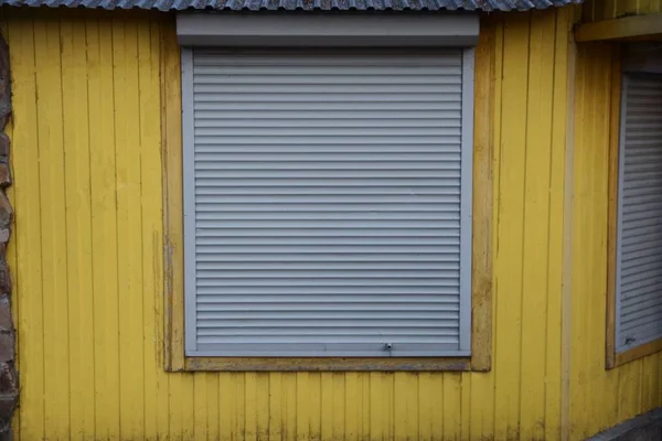 Сірі Жалюзі Закритому Вікні Жовтій Стіні Будівлі — стокове фото