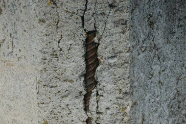 Kahverengi paslı demir takviyeli gri beton duvar